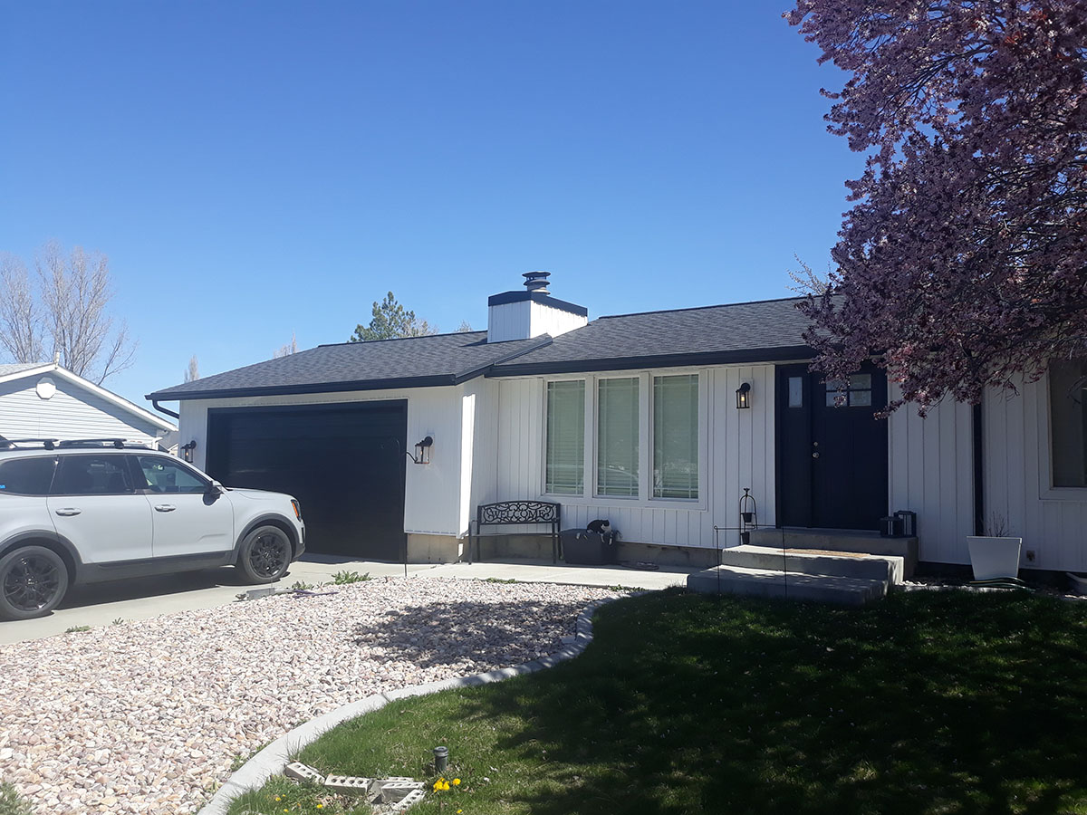 House with gravel driveway and new white siding