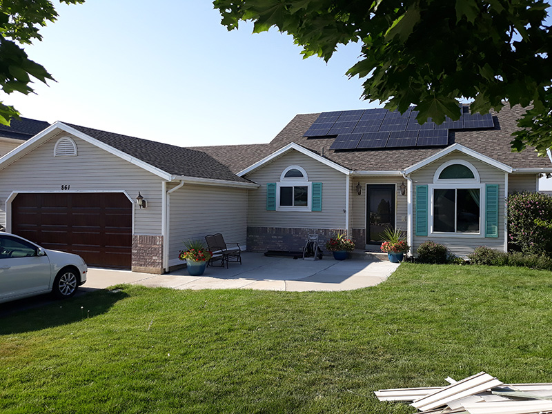 Cream colored ranch style home with teal window shutters