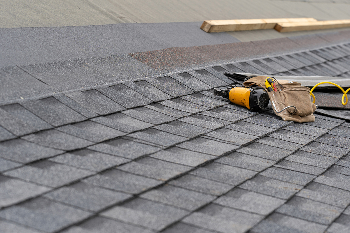 Roofing tools are gray asphalt roof shingles