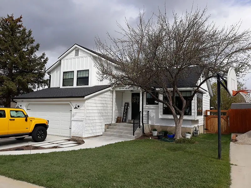 House with gravel driveway and new white siding